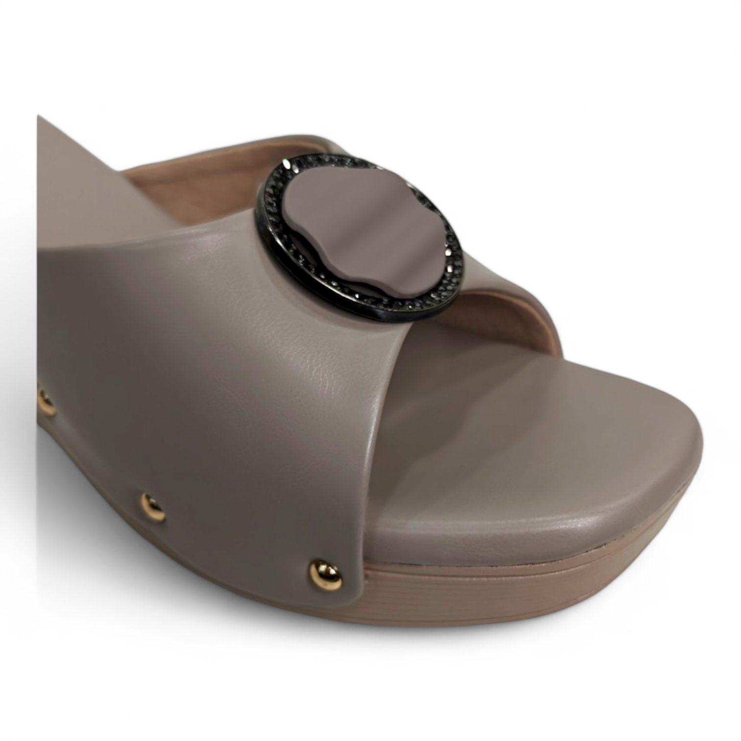 Close-up of embellished circle buckle on brown wedge heel open toe footwear