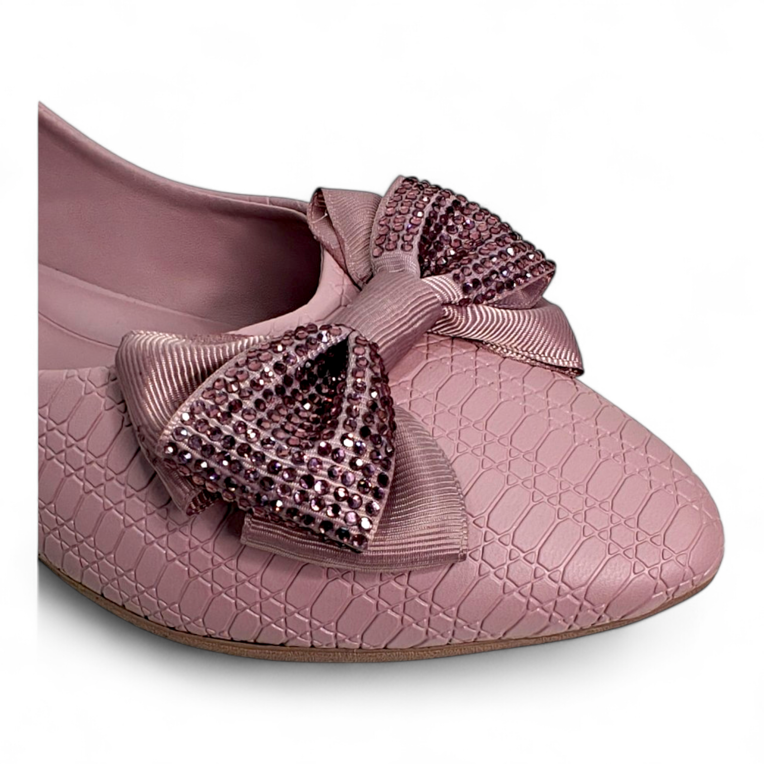 Close-up of embellished bow on top of peach flat bellies made from soft material