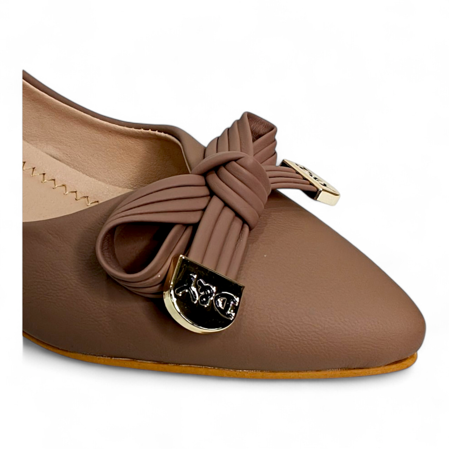 Close-up of bow buckle on tan box heel pumps, highlighting the stylish design