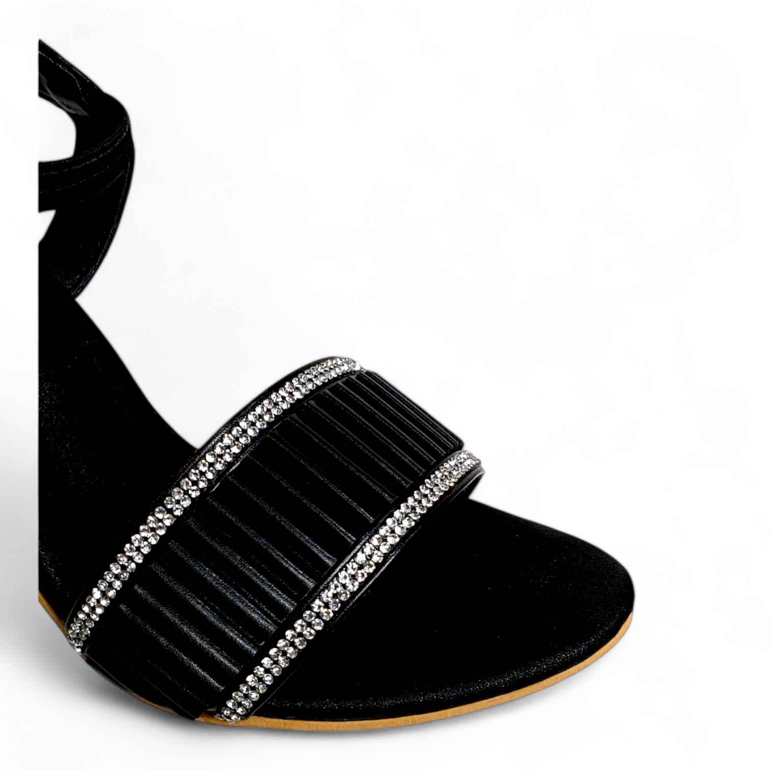 Close-up of diamond-embellished belt on black transparent heel sandal, highlighting the details