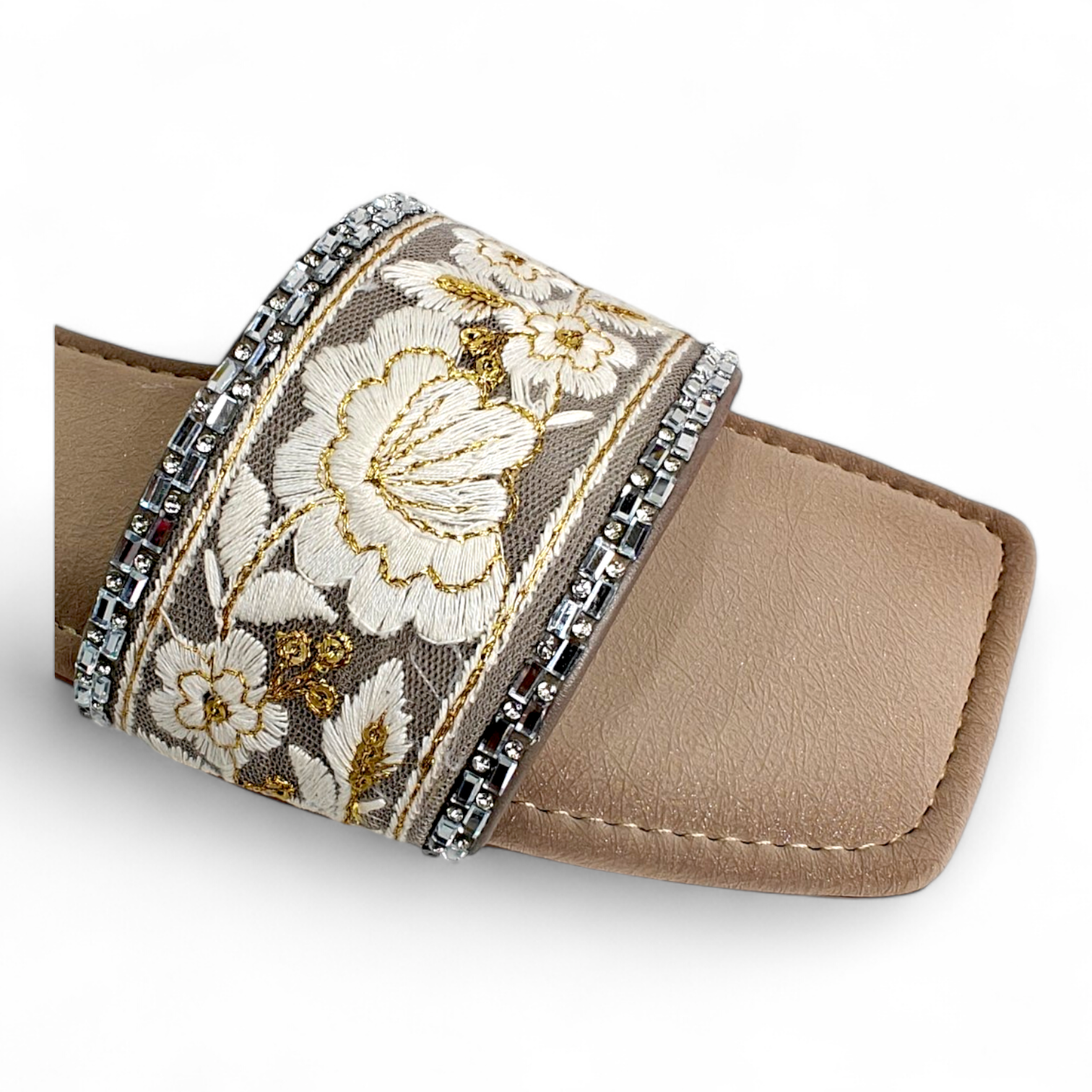 Close-up of floral design on beige flat sliders with open toe