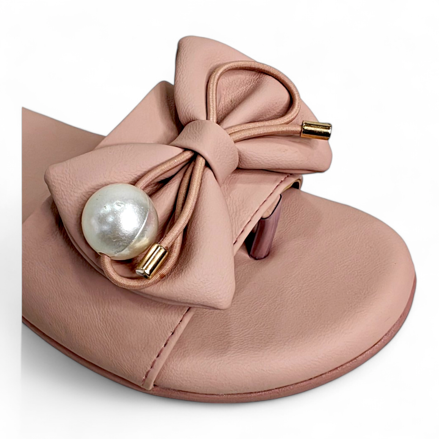 Close-up of bow with pearl detail on peach flats sliders, open toe women's footwear