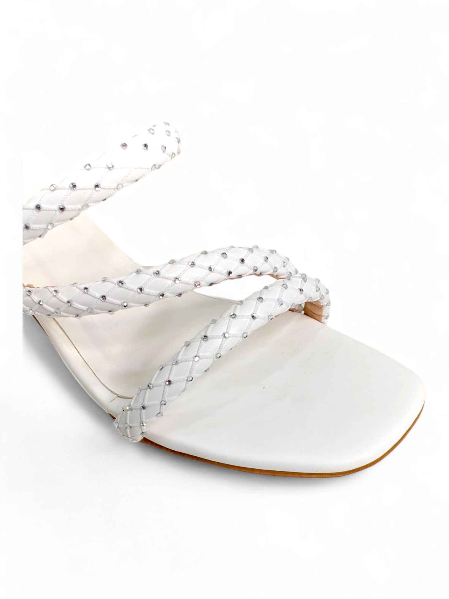 Close-up of braided strap texture and toe-ring detail on white heel sandals