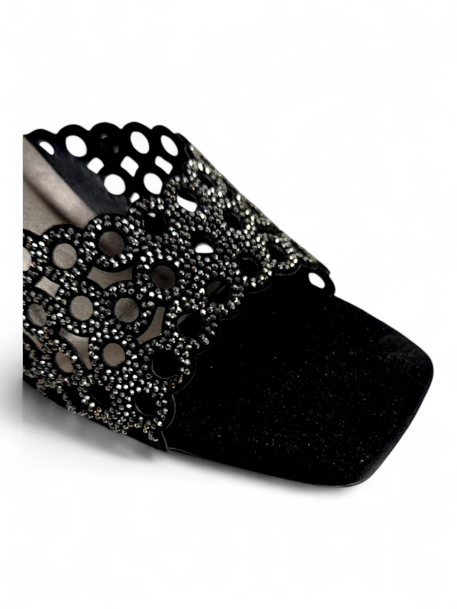 Close-up of stone-embellished cutwork strap design on black women’s heels