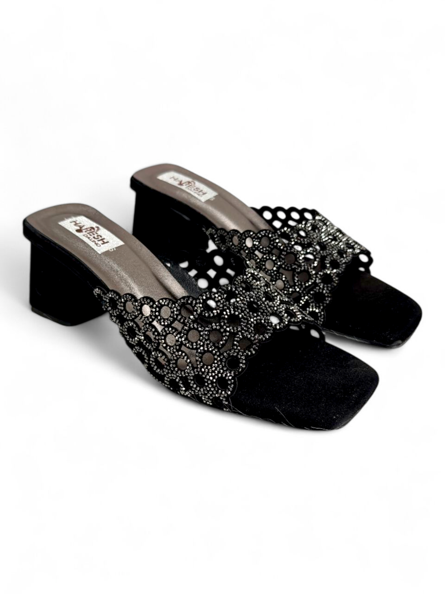 Top angle showing cutwork strap and footbed of black embellished heel sandals