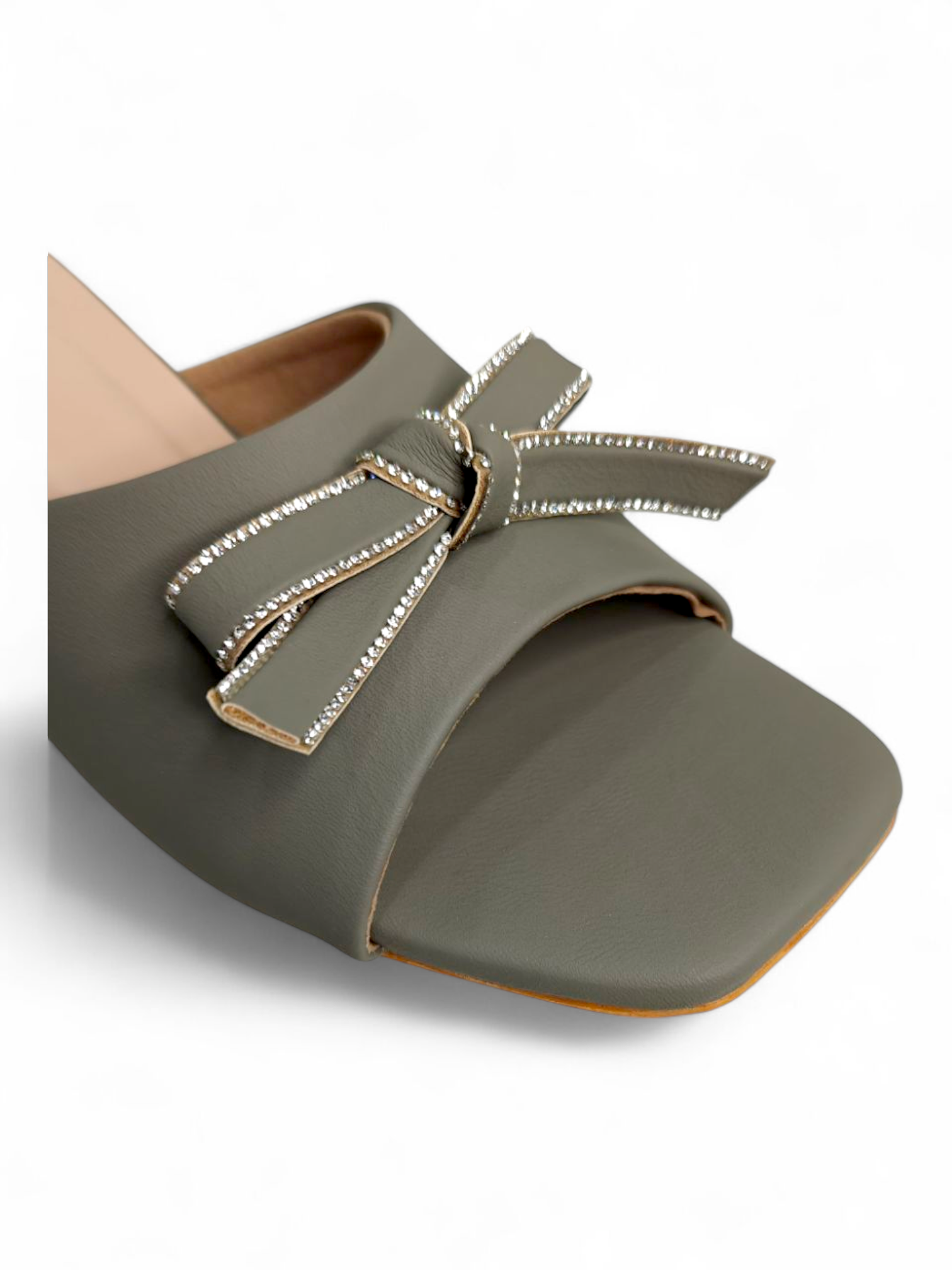 Close-up of bow embellishment and strap stitching on olive block heels