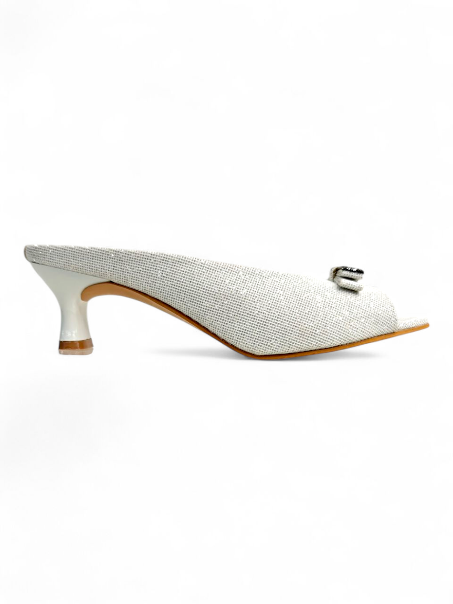 Side profile of white women’s kitten heels with textured upper and buckle