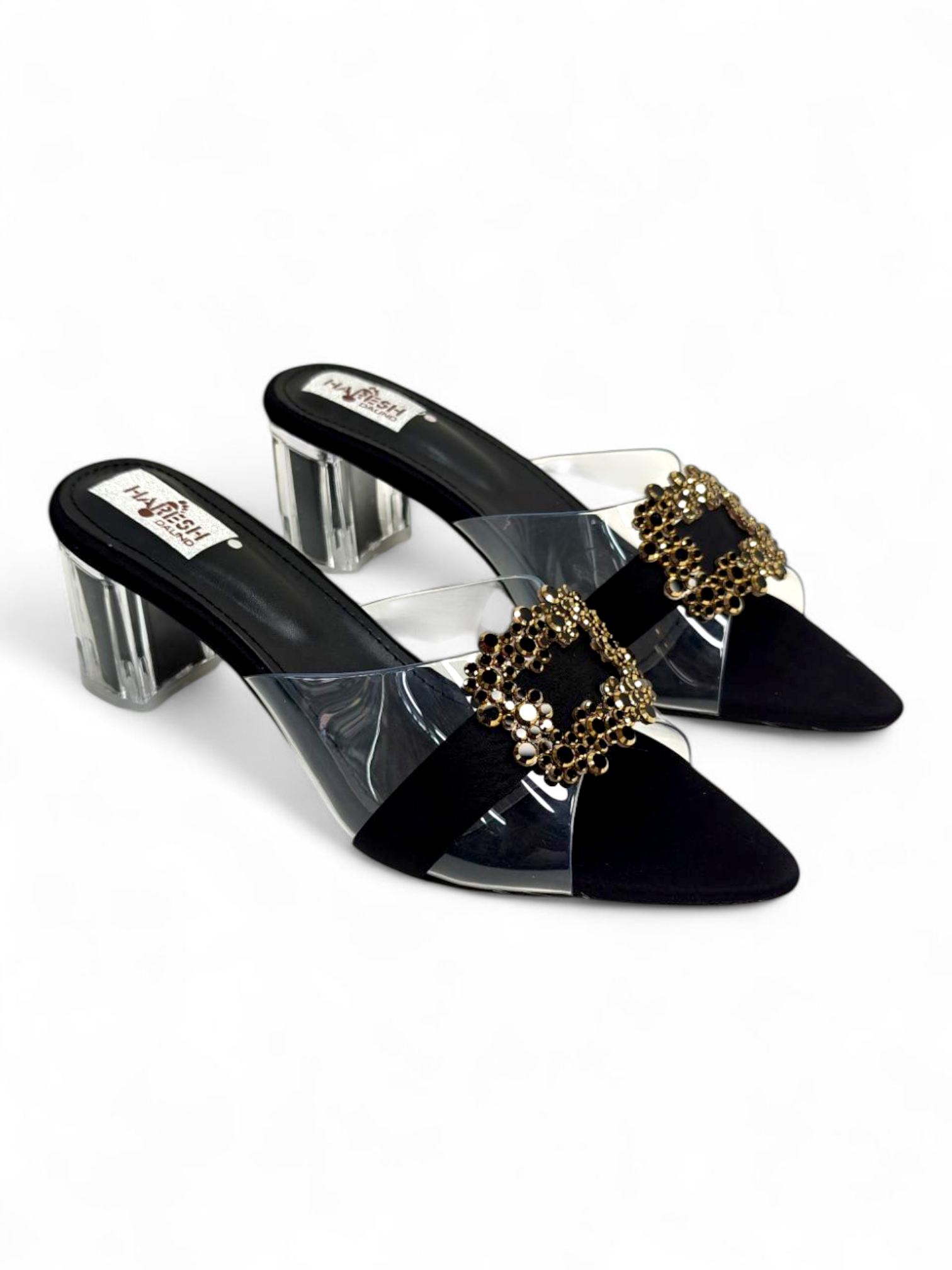 Top angle showing pointed toe and embellished buckle on black sandals