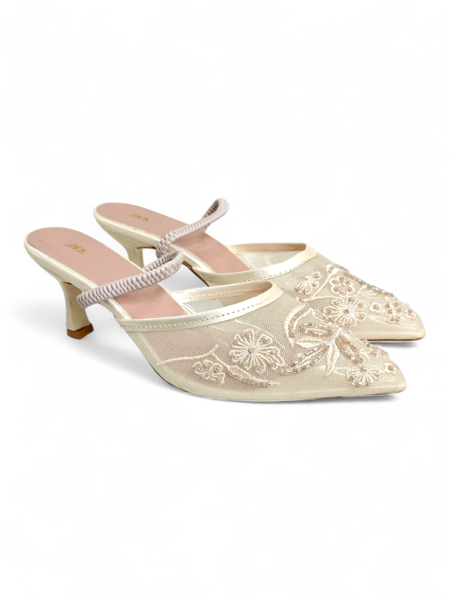 Top angle showing floral embroidery on cream mesh pointed-toe mule heels