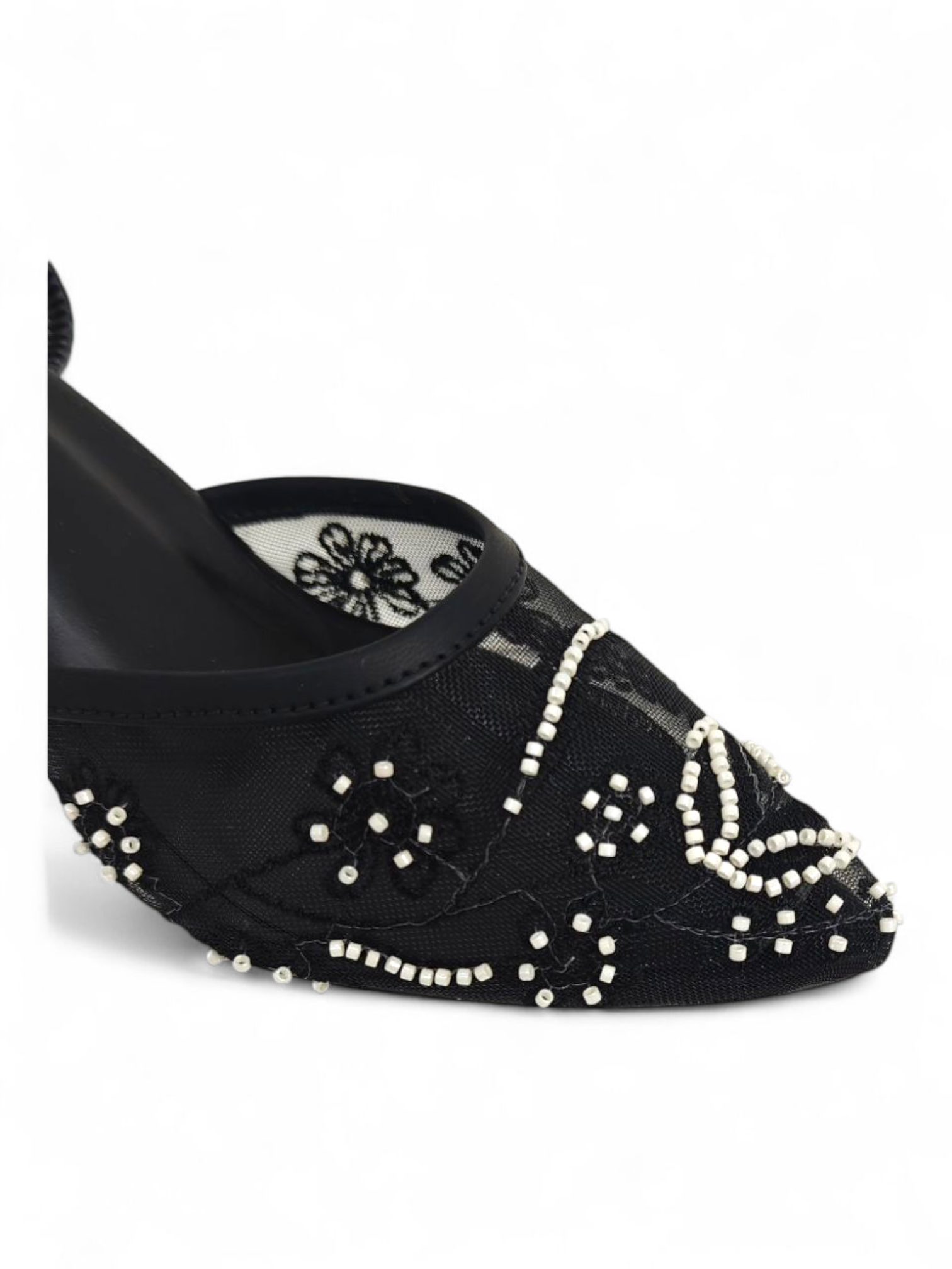 Close-up of pearl embroidery and mesh detailing on black heel sandals