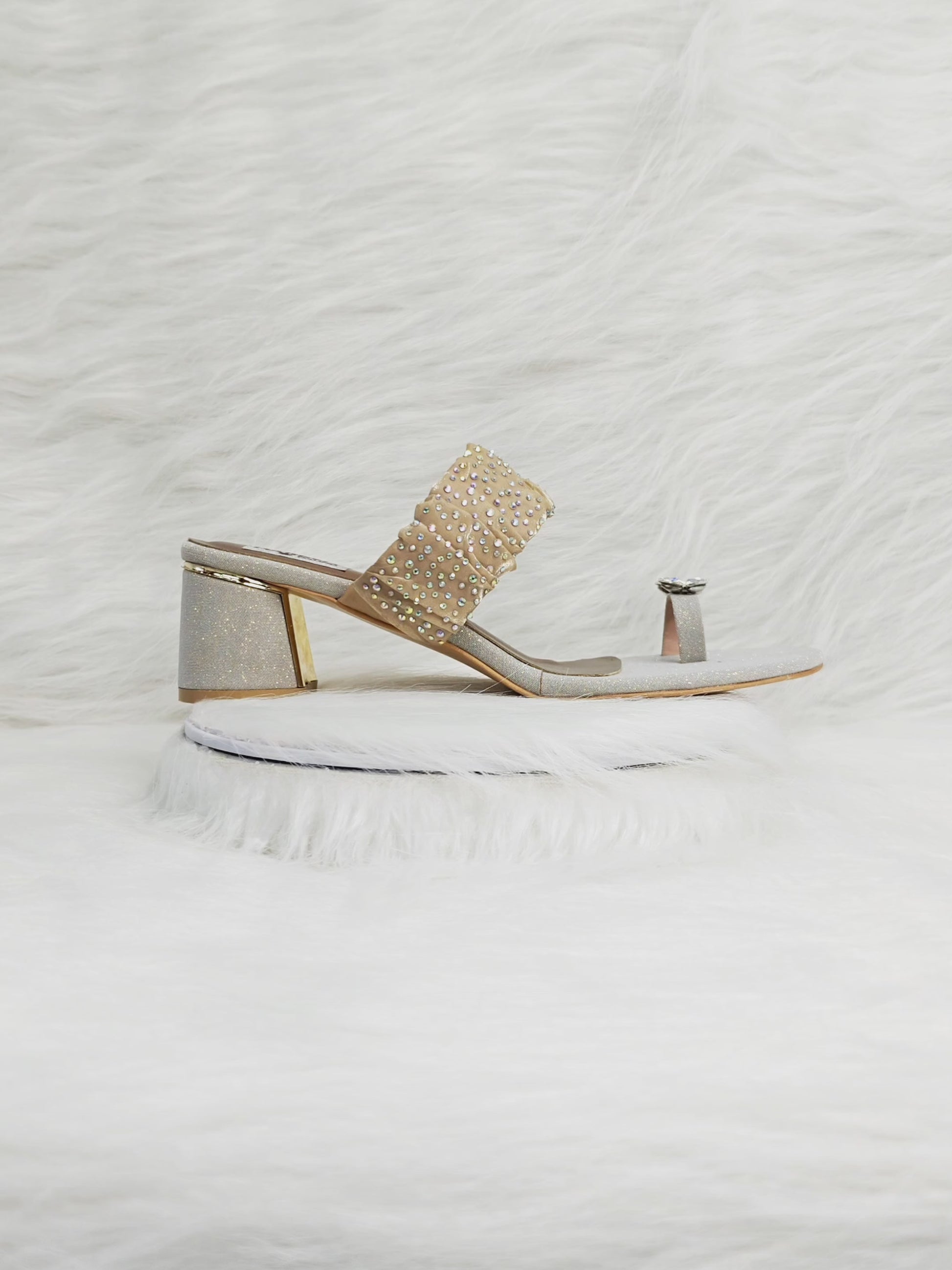 Short video showing golden embellished block heels — close-ups of crystal toe-ring, ruched studded strap, cushioned insole and stable block heel while walking.