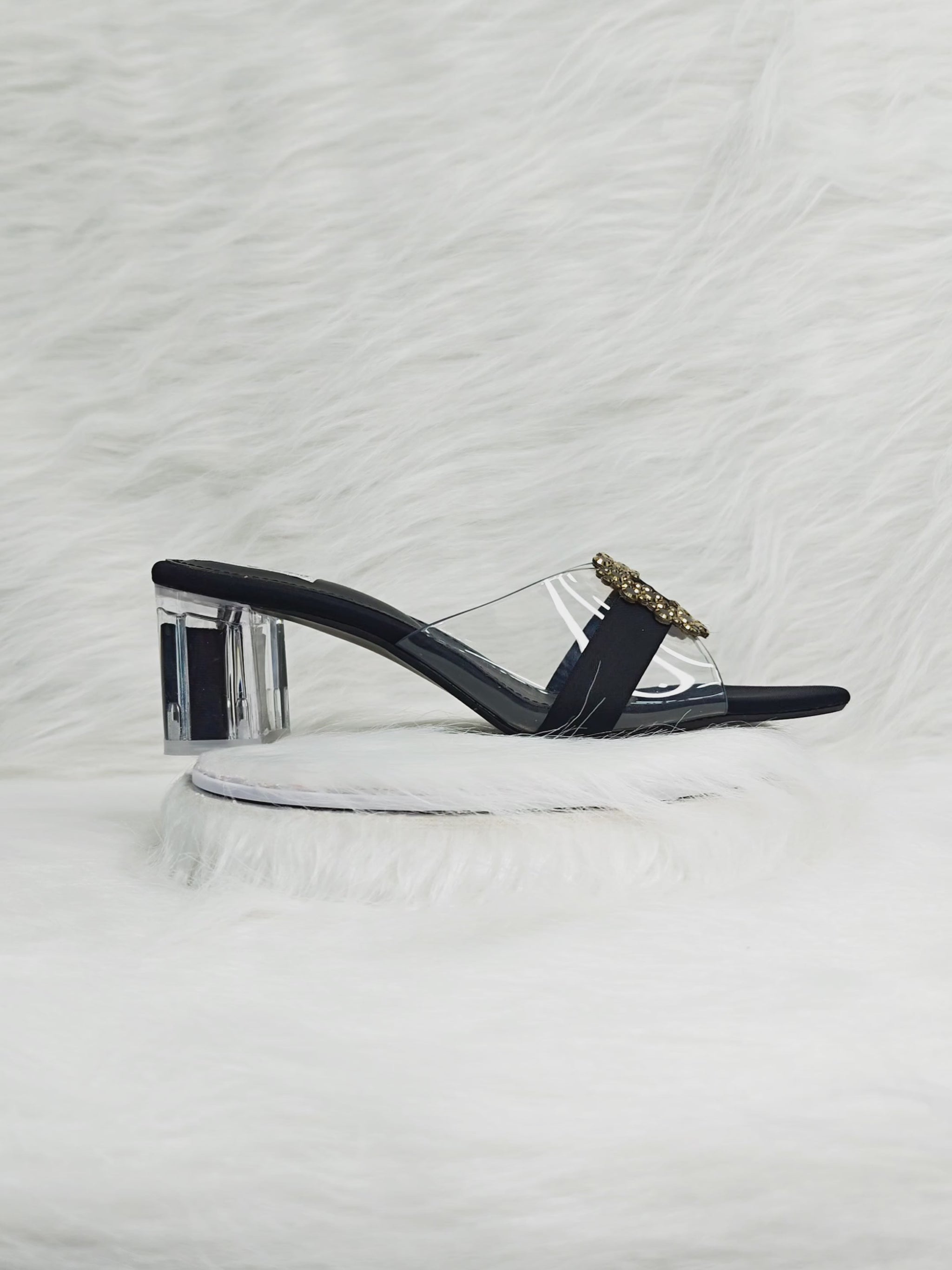 360 degree rotation of black transparent strap sandals with gold embellished buckle and clear block heel