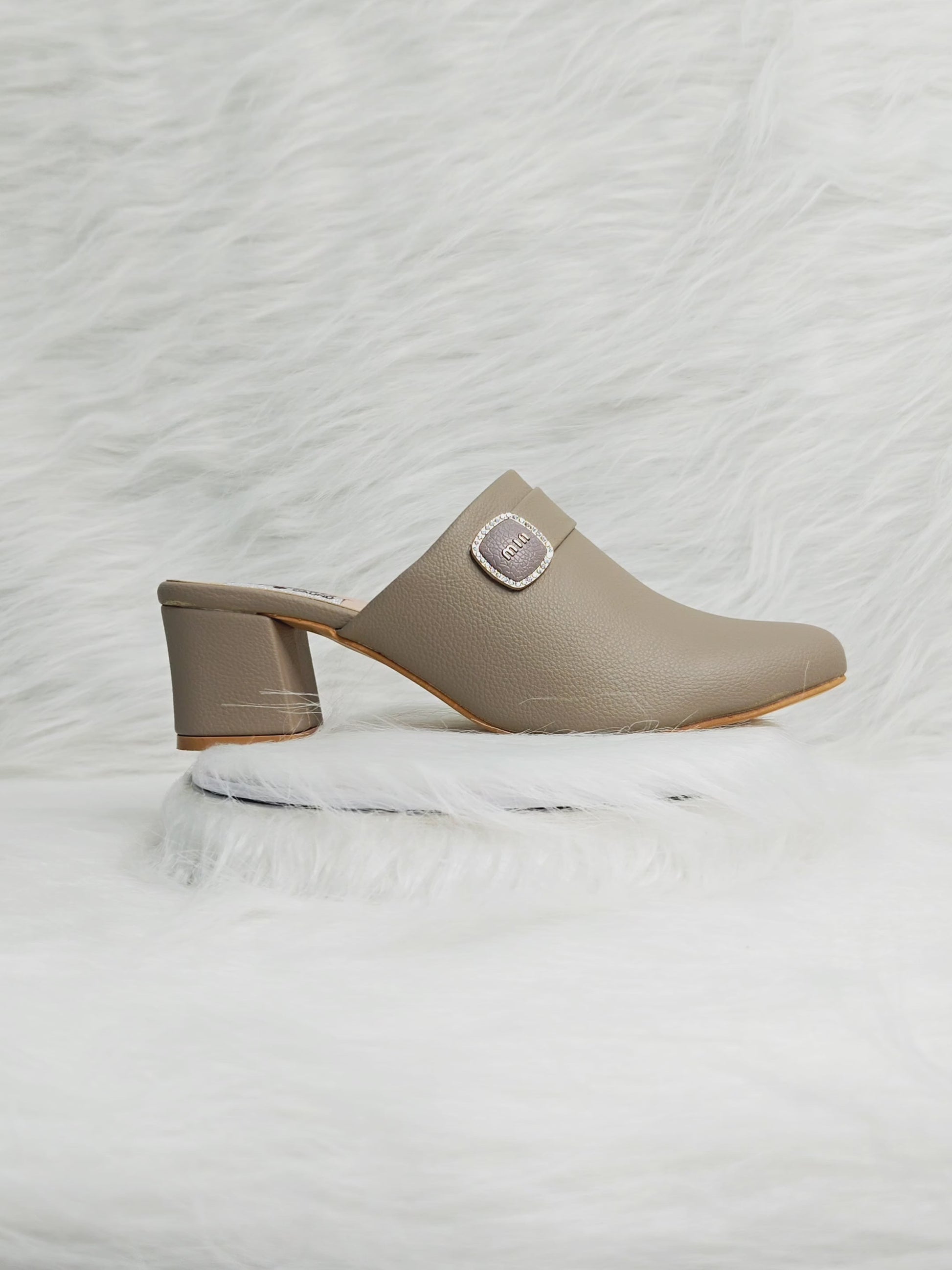 360 degree rotation of taupe closed-toe block heel mules with buckle detail for women