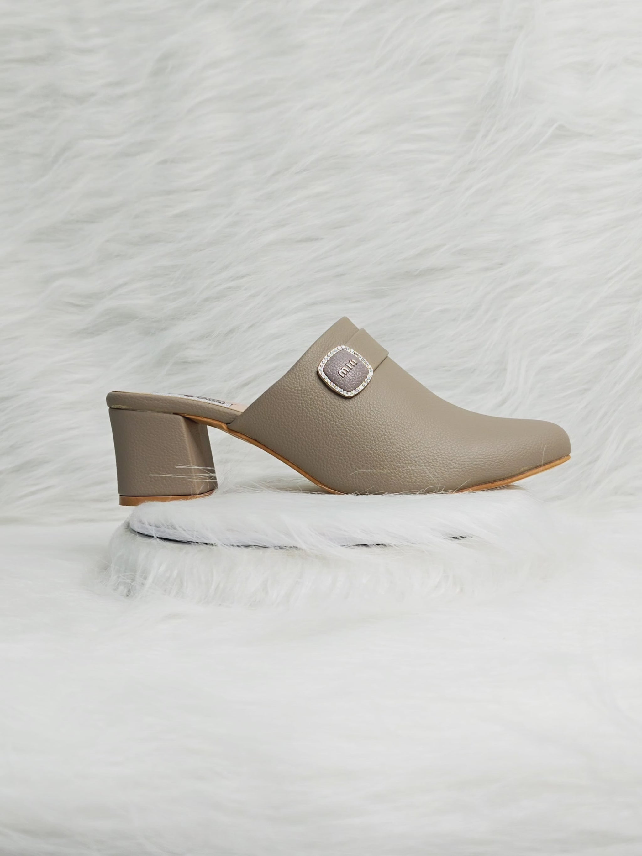 360 degree rotation of taupe closed-toe block heel mules with buckle detail for women