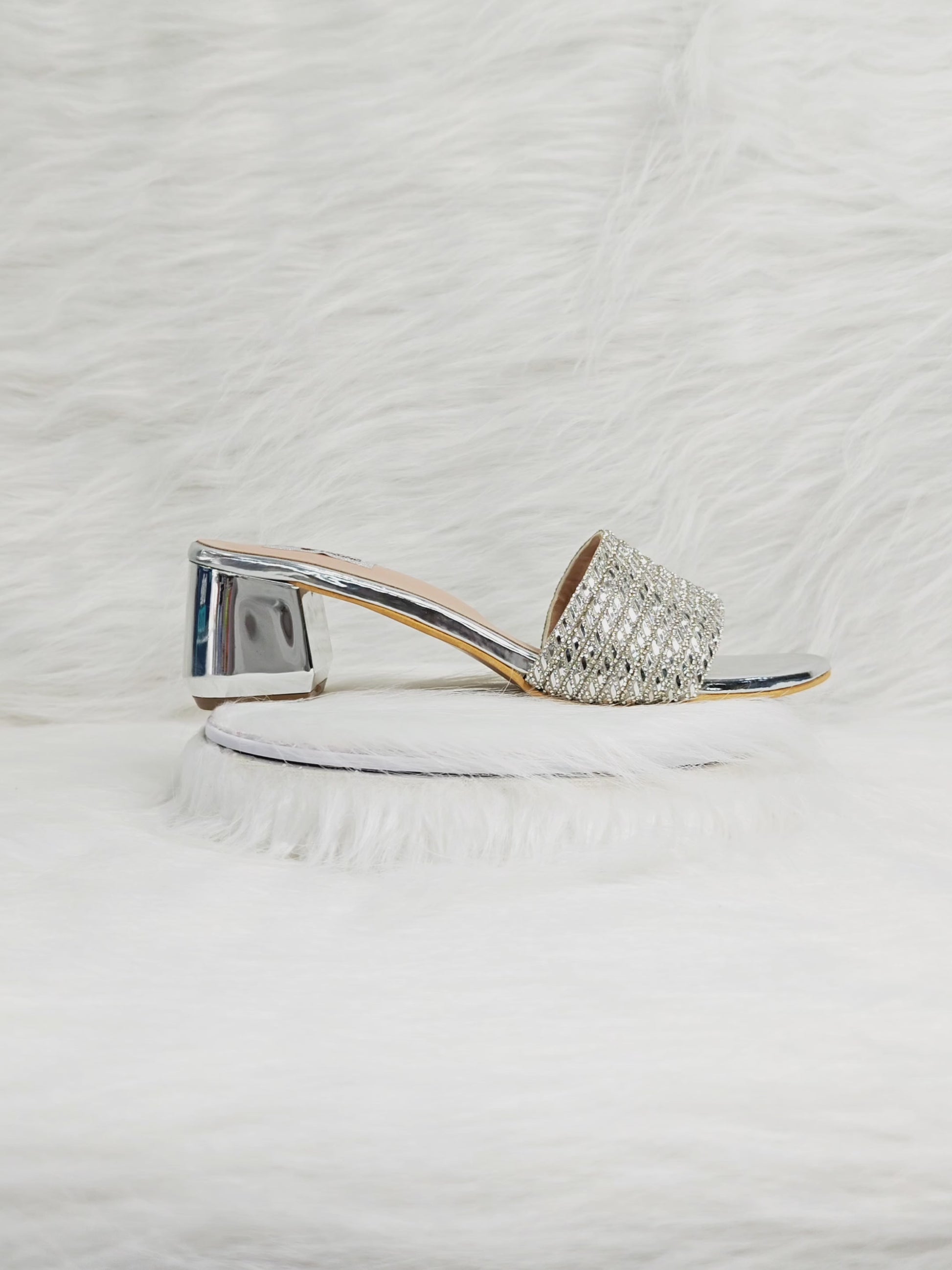 A model walking in silver embellished block heels, showing the sparkle of the strap and comfort of the cushioned sole, styled with Indian festive outfits.